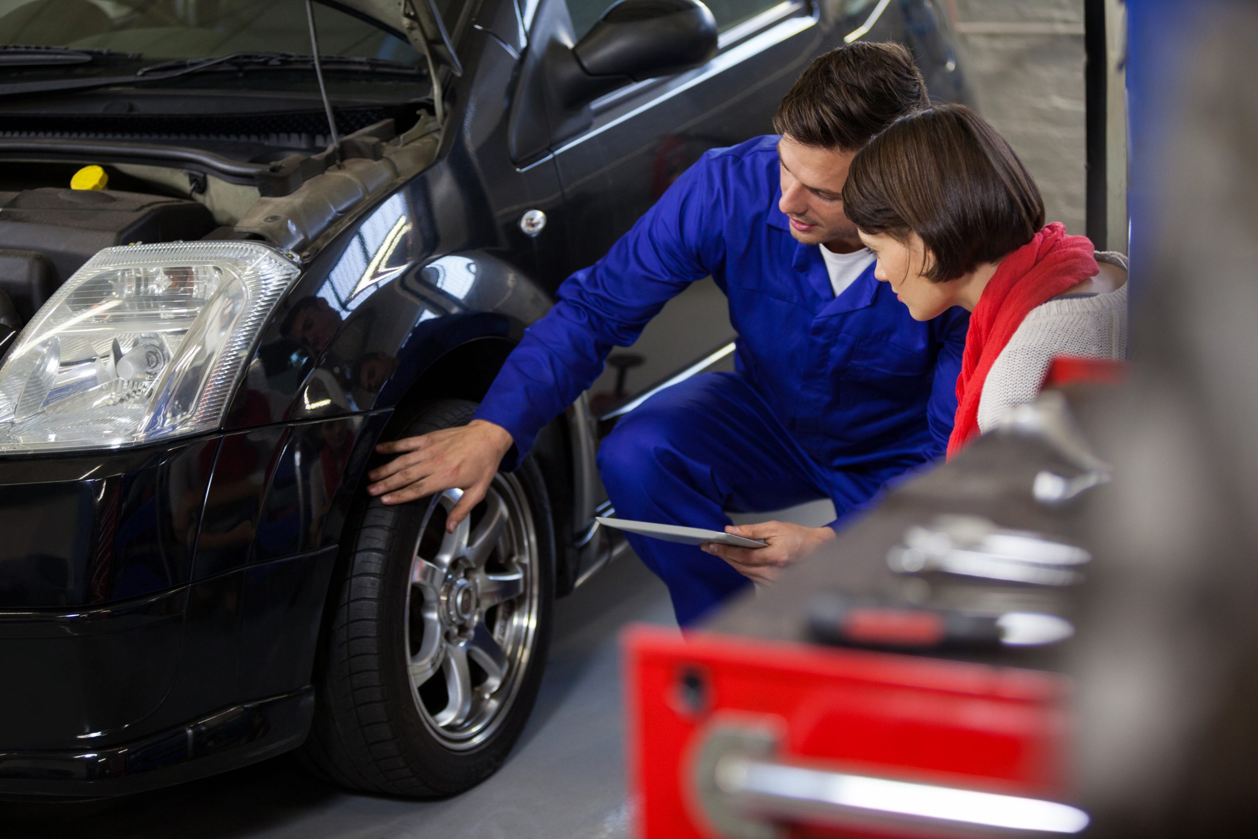 Inicio mechanic showing customer the problem with car